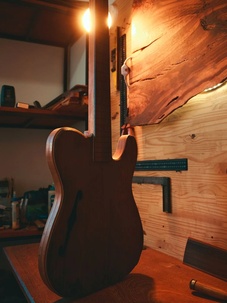 A luthier's workbench with a vintage Japanese guitar in for inspection.