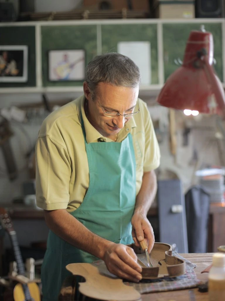 A luthier inspecting a guitar body at the Portland authentication bench